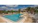Community pool with lounge chairs and umbrellas at 4532 Longwater Chase # 37, Sarasota, FL 34235