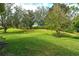 Expansive backyard with lush green grass and mature trees, perfect for outdoor activities at 5097 Faberge Pl, Sarasota, FL 34233
