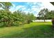 Large backyard with green grass, tropical trees and plants, great for landscaping at 5097 Faberge Pl, Sarasota, FL 34233