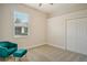 Well-lit bedroom features neutral carpet, a plush chair and an ottoman near a bright window at 5097 Faberge Pl, Sarasota, FL 34233