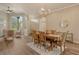 Open dining area with wood table, chairs, chandelier, and access to living area at 5097 Faberge Pl, Sarasota, FL 34233