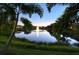 Serene pond view at dusk with a fountain, framed by palm trees at 5097 Faberge Pl, Sarasota, FL 34233
