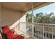 Relaxing screened balcony with red chairs and view of trees at 5281 Mahogany Run Ave # 822, Sarasota, FL 34241
