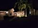 Night view of charming home with palm trees and landscape lighting at 5492 Hampstead Heath # 11, Sarasota, FL 34235