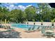 Community pool with plenty of lounge chairs and umbrellas at 5492 Hampstead Heath # 11, Sarasota, FL 34235