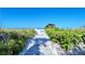 Walkway to the beach, lush landscaping, and a shaded seating area at 6047 E Peppertree Way # 224, Sarasota, FL 34242