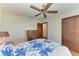 Bedroom with wood floors, ceiling fan, and double door closet at 6300 26Th E Ave, Bradenton, FL 34208