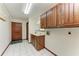 Laundry room with wood cabinets, sink, and tile floors at 6300 26Th E Ave, Bradenton, FL 34208