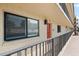 Building exterior showcasing a walkway, red door, and window with shutters at 6326 Midnight Pass Rd # 101, Sarasota, FL 34242