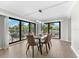 Dining room features a glass table and six brown leather chairs, with access to a balcony at 6326 Midnight Pass Rd # 101, Sarasota, FL 34242
