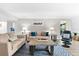 Living room featuring beige sofas, a coffee table, and balcony access at 6326 Midnight Pass Rd # 101, Sarasota, FL 34242