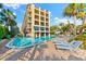 Inviting pool area with lounge chairs, located adjacent to a charming three-story building at 6326 Midnight Pass Rd # 101, Sarasota, FL 34242