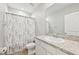 Bright bathroom featuring a granite countertop, white cabinets, and neutral shower curtain at 6620 Serenity Fall Ln, Sarasota, FL 34240