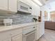 White kitchen with cooktop and built-in oven at 7207 Saint Johns Way, University Park, FL 34201