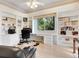 Home office with built-in bookshelves and a large window overlooking the backyard at 7207 Saint Johns Way, University Park, FL 34201