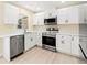 Modern kitchen with white cabinets, stainless steel appliances, and light wood floors at 727 N Jefferson Ave # 727, Sarasota, FL 34237
