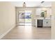 Bright kitchen features white shaker cabinets, stainless steel appliances, and sliding glass doors to patio at 727 N Jefferson Ave # 727, Sarasota, FL 34237