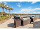 Relaxing lakefront patio with wicker furniture and a fire pit, perfect for socializing at 7620 Summerland Cv, Bradenton, FL 34202