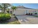 Tan two-car garage house with gray paver driveway at 7668 Registrar Way, Sarasota, FL 34243