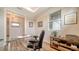 Home office features a glass desk and hardwood floors at 7668 Registrar Way, Sarasota, FL 34243
