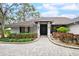 Front entrance of a white brick home with landscaping and paver driveway at 869 Forestview Dr, Sarasota, FL 34232