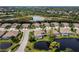 Wide aerial view of lakefront homes and surrounding landscape at 8737 Pebble Creek Ln, Sarasota, FL 34238