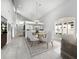 Open dining room with large chandelier and view to kitchen at 8737 Pebble Creek Ln, Sarasota, FL 34238