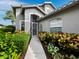 Welcoming entryway with gray walls, a dark gray door, and tasteful landscaping at 8737 Pebble Creek Ln, Sarasota, FL 34238