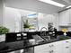 Kitchen with black granite countertops, stainless steel sink, and view to Gathering room at 8737 Pebble Creek Ln, Sarasota, FL 34238