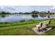 Serene lake view with a fountain and bench at 8737 Pebble Creek Ln, Sarasota, FL 34238