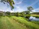 Serene pond view with lush greenery and reflection of clouds at 8737 Pebble Creek Ln, Sarasota, FL 34238