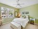 Guest bedroom with light green walls, a comfortable bed, and a window seat at 9420 Old Hyde Park Pl, Lakewood Ranch, FL 34202