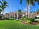 Two-story house with tile roof, lush landscaping, and three-car garage at 9420 Old Hyde Park Pl, Lakewood Ranch, FL 34202