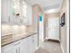 Clean hallway with white cabinets, granite countertop, and tile flooring at 9420 Old Hyde Park Pl, Lakewood Ranch, FL 34202