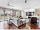 Spacious living room with hardwood floors, large windows, and comfortable seating at 9420 Old Hyde Park Pl, Lakewood Ranch, FL 34202