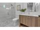 Clean bathroom with a glass-door shower, wood vanity and pebble floor at 105 6Th S St, Bradenton Beach, FL 34217