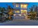 Two-story home with a two-car garage, illuminated at dusk at 105 6Th S St, Bradenton Beach, FL 34217