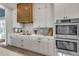 Modern kitchen with white cabinets, stainless steel appliances, and a wooden range hood at 105 6Th S St, Bradenton Beach, FL 34217