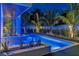 Lighted pool and spa at night with tropical landscaping at 105 6Th S St, Bradenton Beach, FL 34217