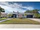Single-story home with gray exterior, tile roof, and landscaped yard at 1051 Truman St, Nokomis, FL 34275