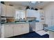Bright kitchen with white cabinets, teal countertops, and stainless steel appliances at 1051 Truman St, Nokomis, FL 34275