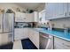Bright kitchen with white cabinets, teal countertops, and stainless steel appliances at 1051 Truman St, Nokomis, FL 34275