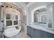 Primary bathroom featuring a large soaking tub, and vanities, and marble finishes at 11432 Savannah Lakes Dr, Parrish, FL 34219