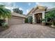 Elegant home exterior with a brick driveway and palm trees at 11432 Savannah Lakes Dr, Parrish, FL 34219