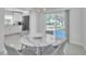 Modern dining area with round table and gray chairs, near kitchen at 120 Edgewater Ter, Dunedin, FL 34698