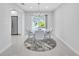 Modern dining area with round table and gray chairs, near kitchen at 120 Edgewater Ter, Dunedin, FL 34698