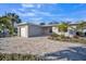 Updated home exterior boasts a gray facade, pink door, and a paved driveway at 120 Edgewater Ter, Dunedin, FL 34698