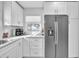 Modern kitchen features white cabinets, granite countertops and stainless steel appliances at 120 Edgewater Ter, Dunedin, FL 34698