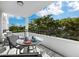 Outdoor balcony with table and chairs, providing a scenic treetop view at 1255 N Gulfstream Ave # 204, Sarasota, FL 34236