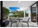 Private balcony with outdoor seating and lush tropical foliage views at 1255 N Gulfstream Ave # 204, Sarasota, FL 34236